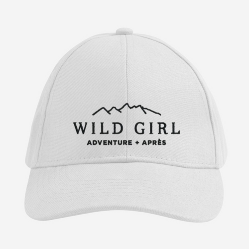 White cap with 'Wild Girl Adventure + Après' embroidered text on a white background