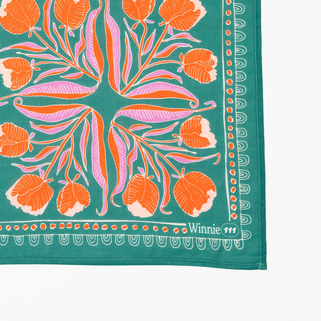 Floral patterned fabric with orange flowers and green background, featuring the brand 'Winnie 111'.