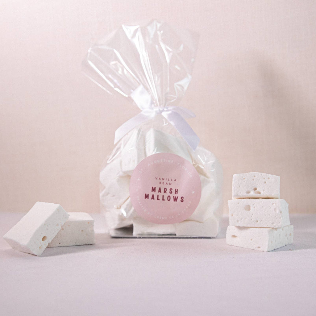 Pink marshmallow in a clear cellophane bag with white packaging on a light pink background