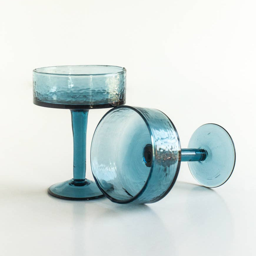 Two blue glass goblets on a white background