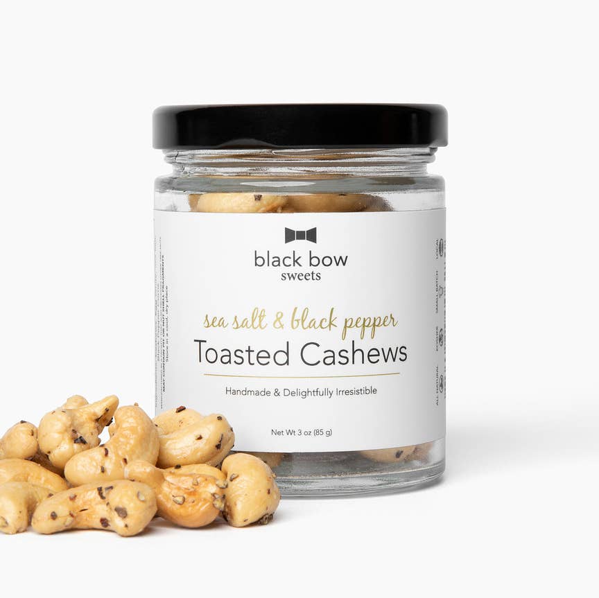 Jar of sea salt and black pepper toasted cashews with a 'black bow sweets' label on a white background.