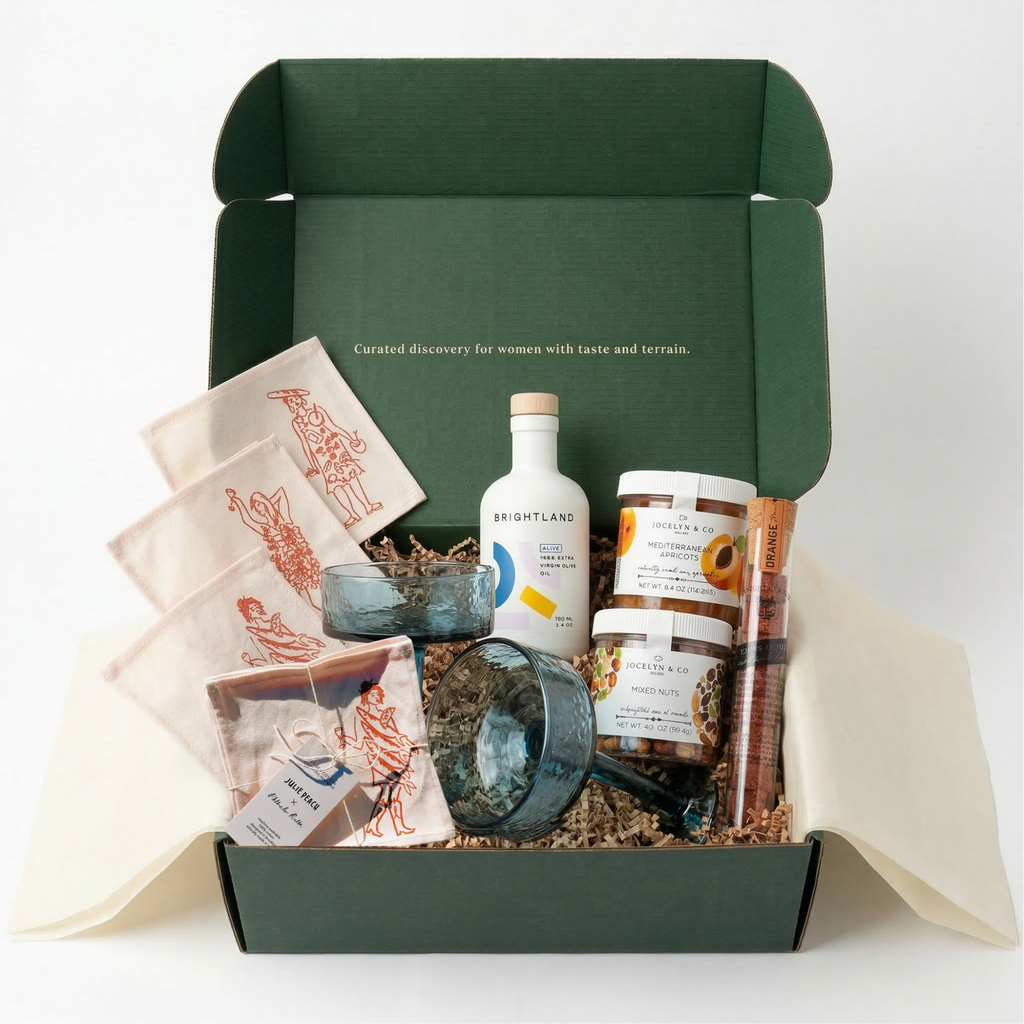 Wild Girl Gifts Entertain Edit gift box with Creative Women handblown glasses, Brightland olive oil, and Julie Peach napkins