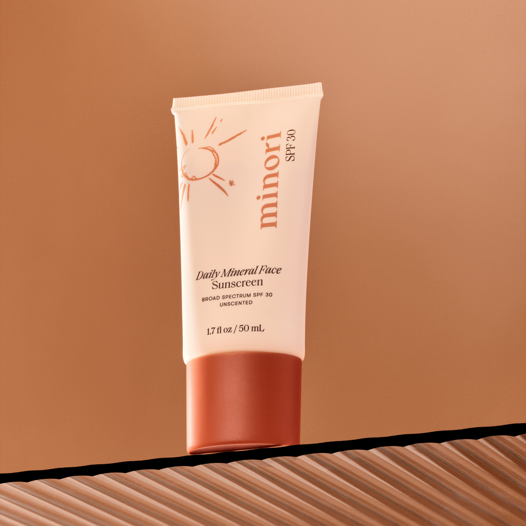 Tube of minori Daily Mineral Face Sunscreen on a brown background