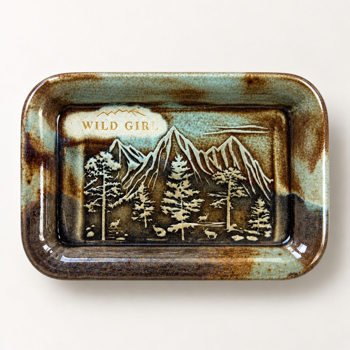 Wild Girl ceramic soap dish in the Rustic Brown glaze, tobacco and sage with copper tones, with an embossed mountain range, pine trees and deer.